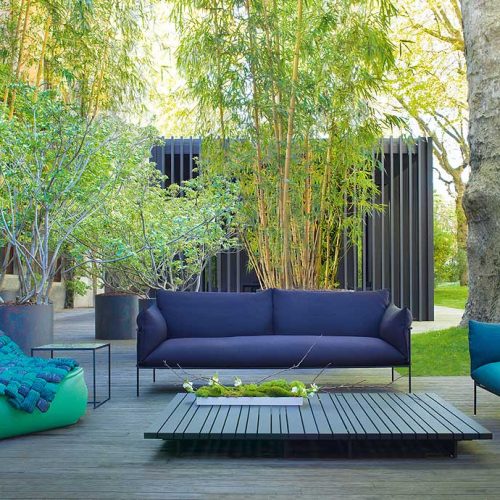 Kabà Armchair, cover in blue polyester, structure and four legs in black steel in a terrace.