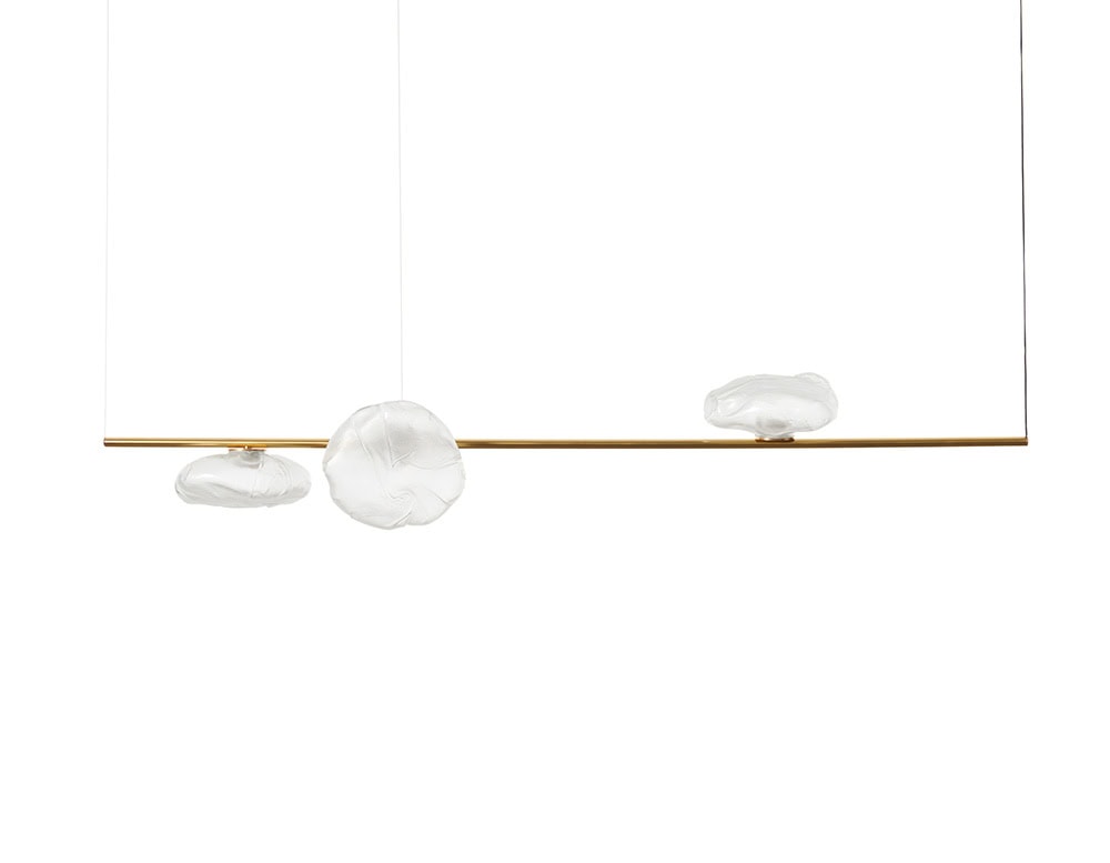 Boc Stem Suspension Light features a slim brass bar suspended by fine cables, with three clear hand-blown glass forms evenly spaced along it. The soft shapes bring an organic feel to the minimalist design.