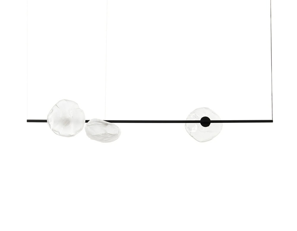 Boc Stem Suspension Light showcases a slim matte black horizontal rod with three clear glass diffusers, each uniquely shaped. The suspended design combines sculptural elegance with modern minimalism in a linear format.