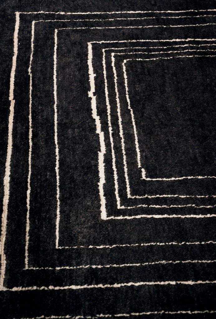 Berbère Dark Grey + Natural | Pattern B. Rug decorated with a woolen stitching.