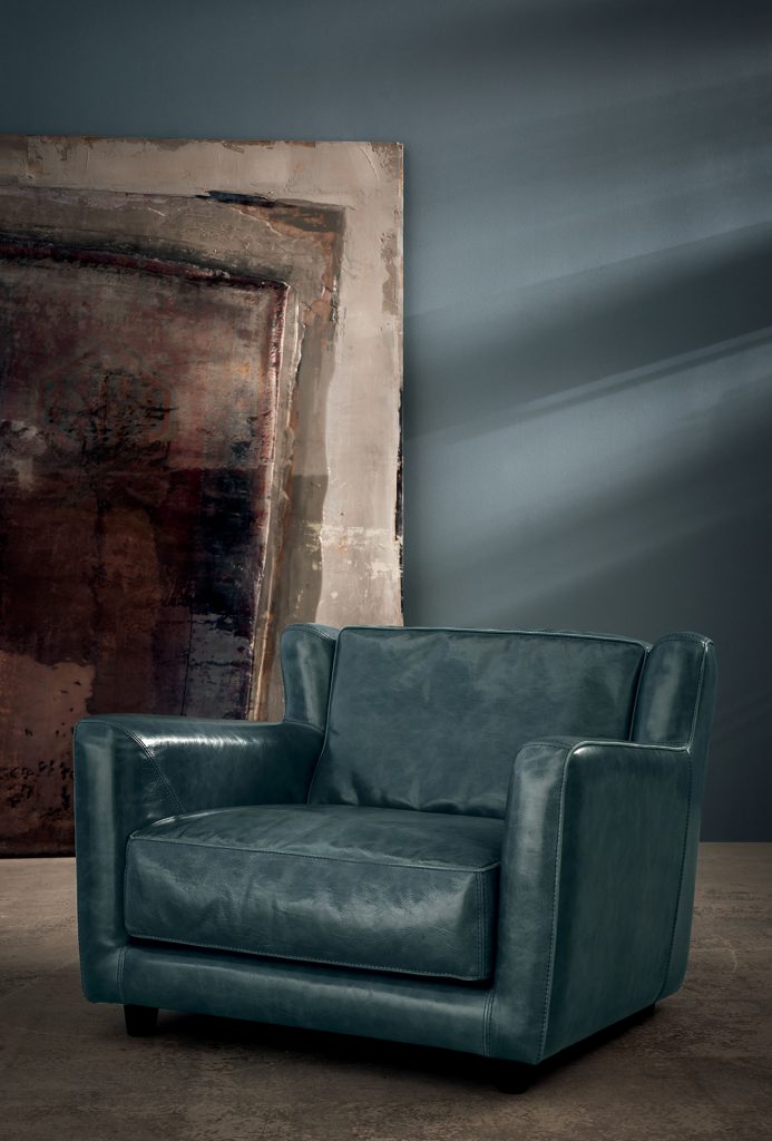 Berge Longe Armchair. Single-part frame. Green Seat cushions and back cushions leather in a living room.