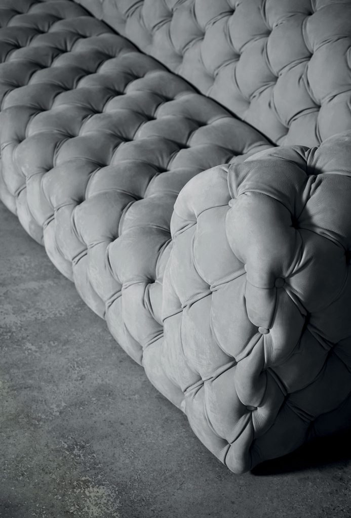 Chester Moon Sofa. Quilted button back model. Structure in fir plywood. Seat frame in fir. Base in wengé-stained beech. Grey acrylic fibre cover in a living room.
