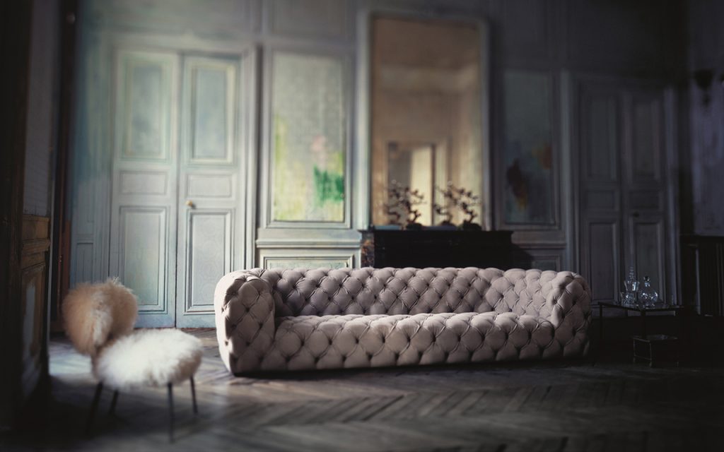 Chester Moon Sofa. Quilted button back model. Structure in fir plywood. Seat frame in fir. Base in wengé-stained beech. Grey acrylic fibre cover in a living room.