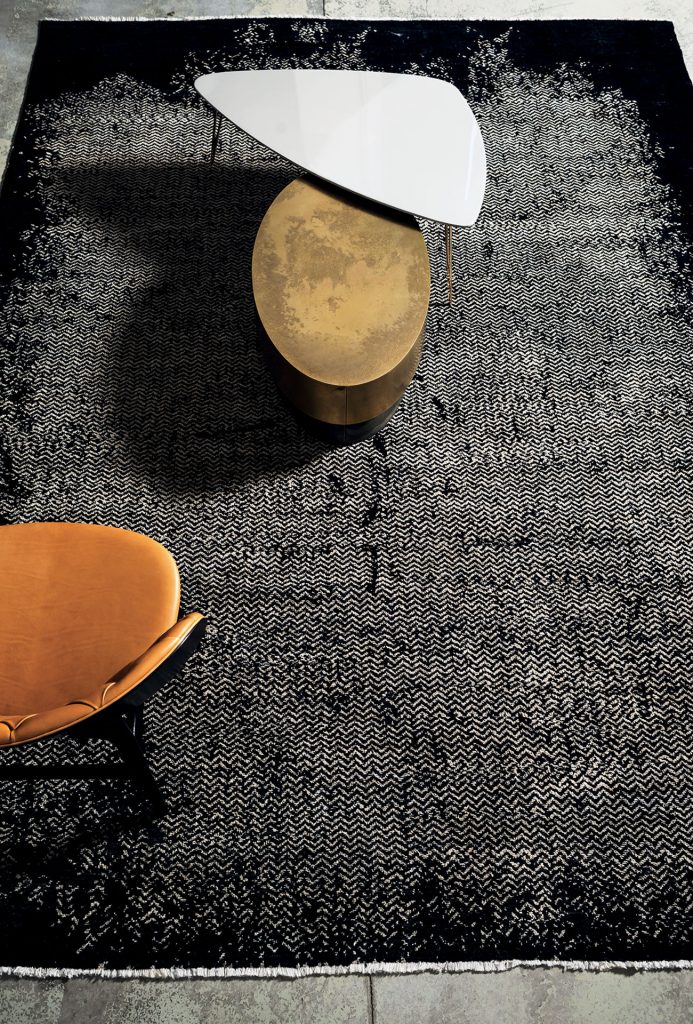 A Scarlet Twill rug, made of wools, hand-dyed in white and black pattern with a chair and a table.