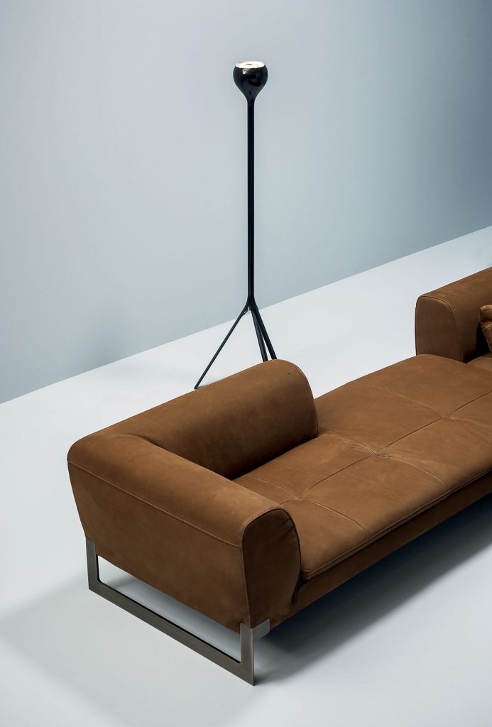 A brown Victor sofa divided into two modules, a module for two. One for two with left low back, a module for two with low back. Brassed metal feet and support hook. Covers in leather in a dining room.
