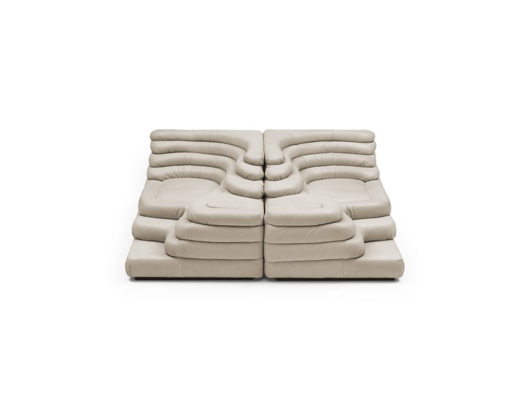 Two white cream DS Thousand twenty five sofa elements. The single element is a terraced hill with widths and depths that vary in tapering steps on a white background.