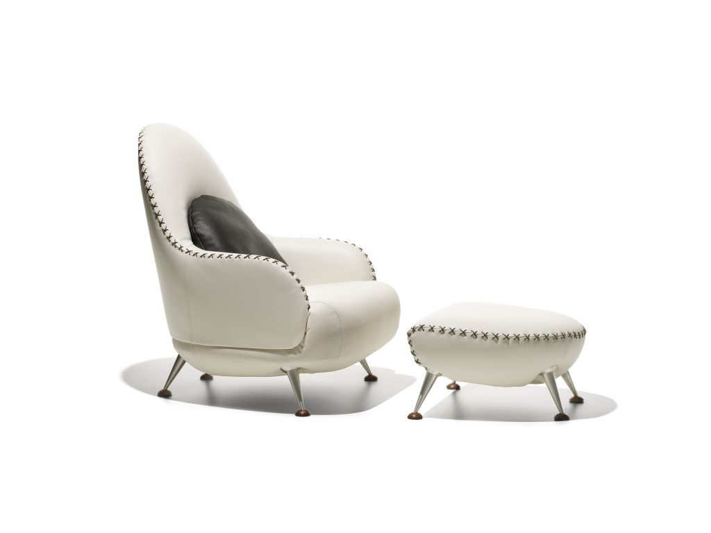 DS hundred two- eleven armchair and footstool. White and black upholstered shell on a white background.