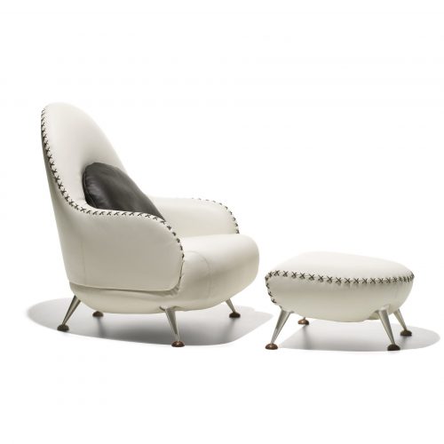 DS hundred two- eleven armchair with footstool. White and black upholstered shell on a white background.