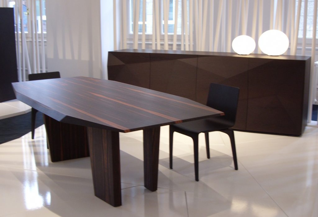 table characterized by the facets on the top made on a wood base flamed in a room