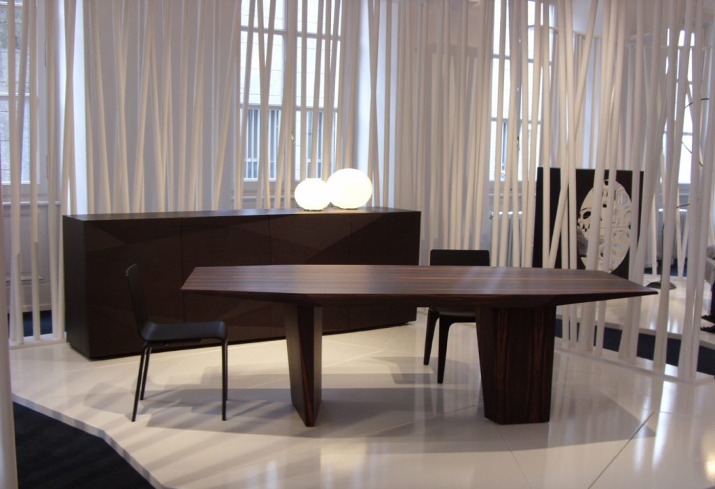 table characterized by the facets on the top made on a wood base flamed in a room