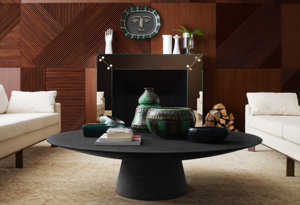Low centrepiece made in the shape of a circle in solid wood in a black colour tone in a living room