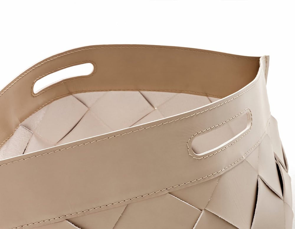 A detailed close-up of the 10th Baskets Tray showcasing its elegantly curved leather handle cutouts and intricate woven leather design in a neutral tone