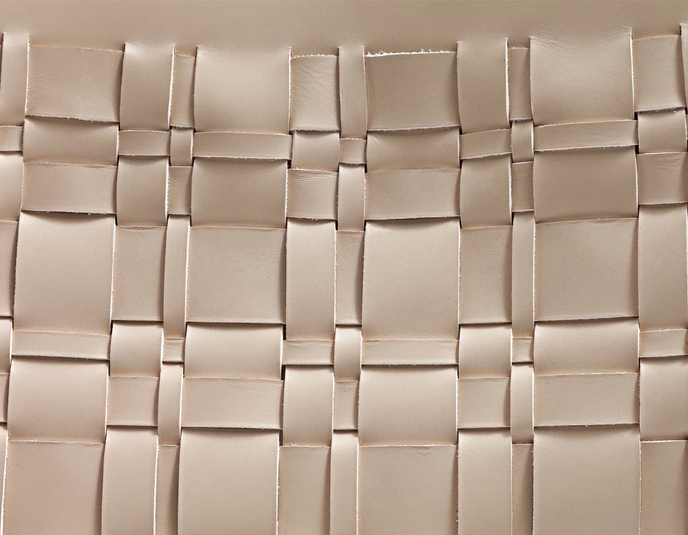 A detailed close-up of the 10th Baskets Tray showcasing its intricate woven leather pattern in a soft neutral tone with precise craftsmanship