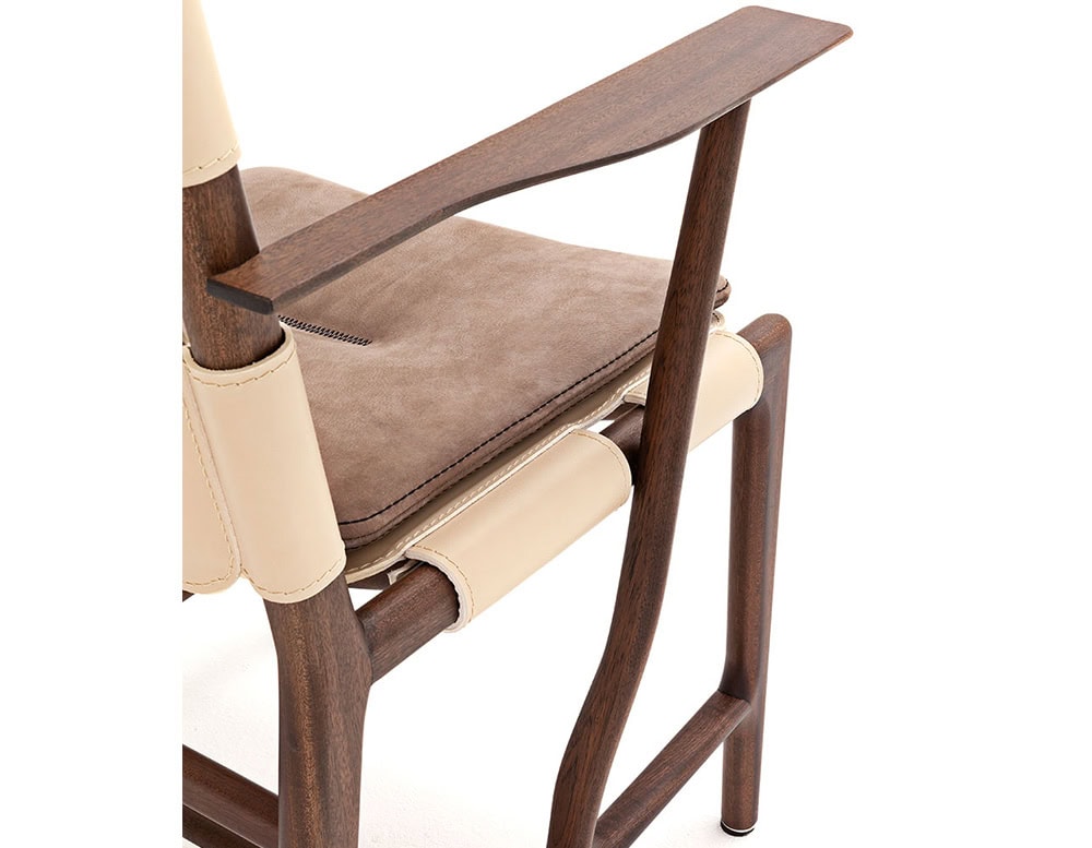 Closeup of Levante Chair. Structure in brown wood, seat and backrest in white leather with brown cushion on a white background.