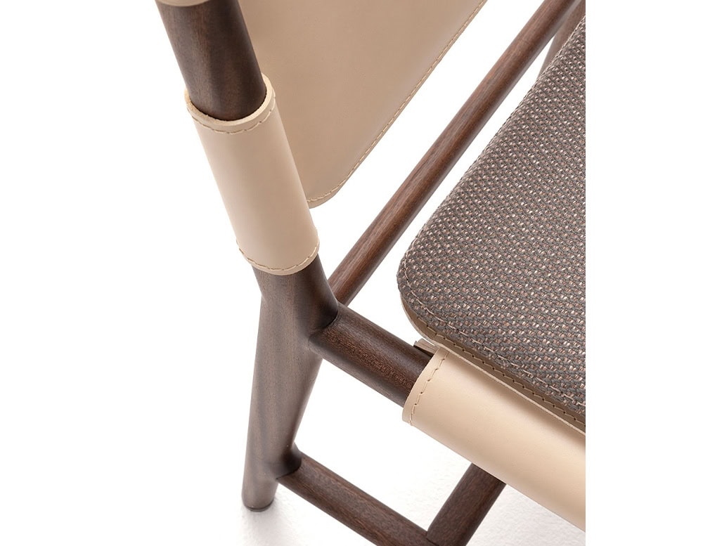 : Closeup of Levante Chair. Structure in brown wood, seat and backrest in white leather on a white background.