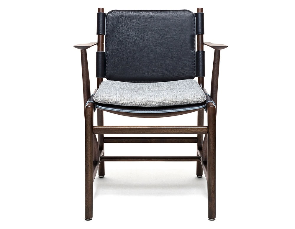 Levante Chair. Structure in brown wood, seat and backrest in black leather with gray cushions on a white backrground.