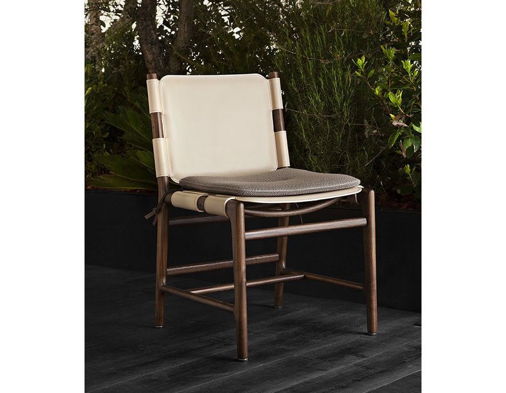 Levante Chair. Structure in brown wood, seat and backrest in white leather with brown cushions on a terrace.