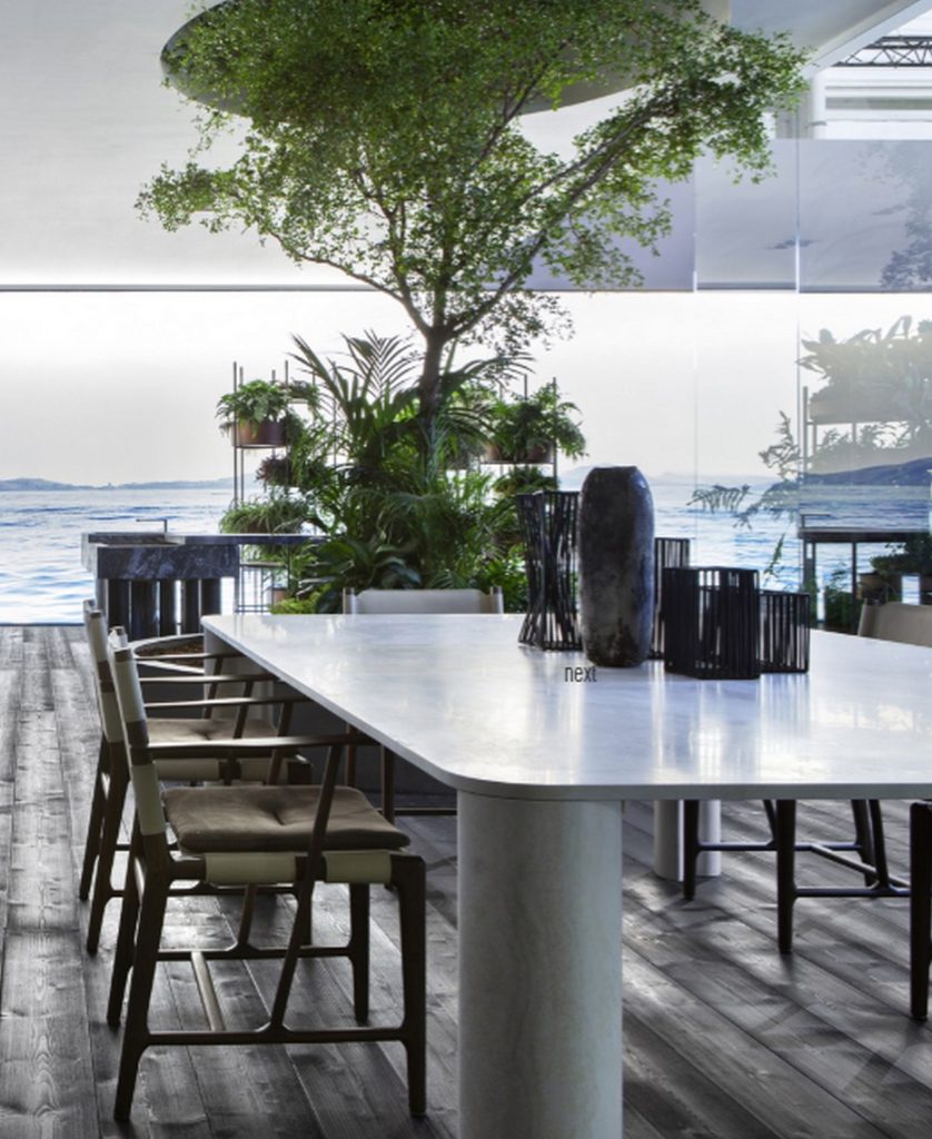 michelangelo dinner table in marble with some wood chairs with an ocean view