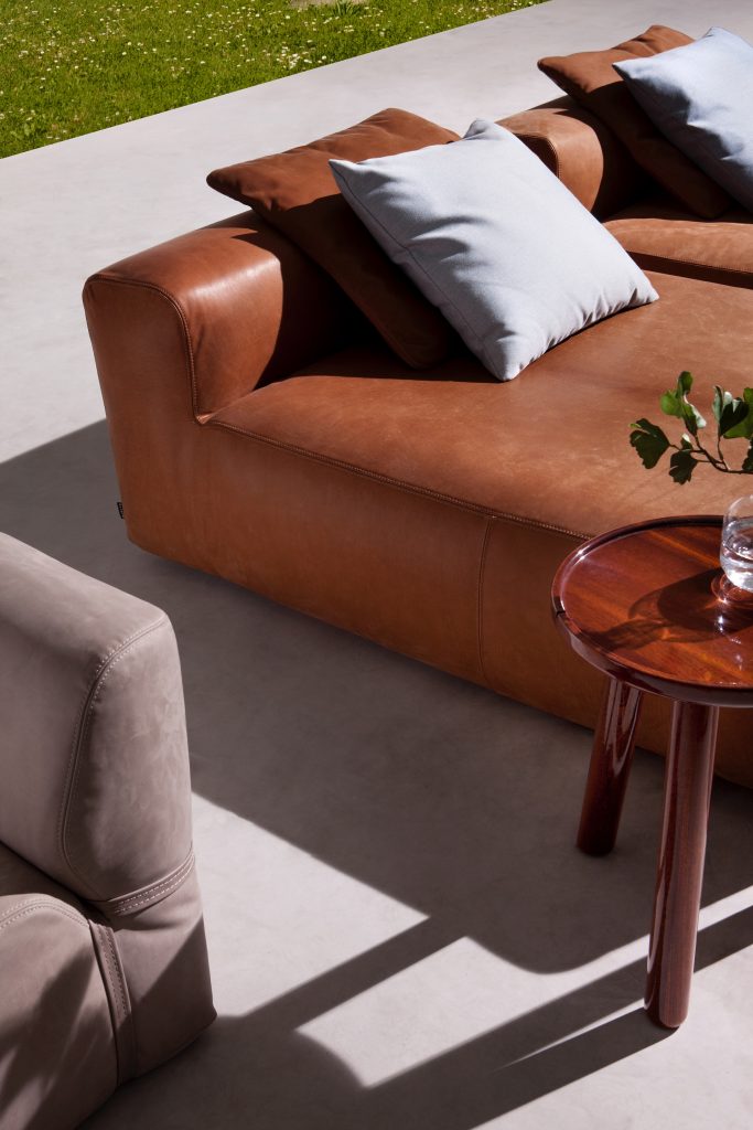 monte carlo chaise lounge in brown leather next to a table