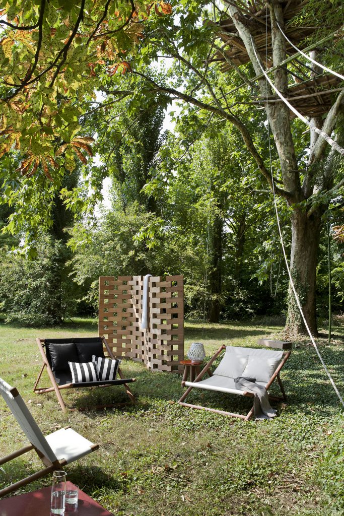 two paraggi sofas one in white fabric, the other one in black in front of a paraggi beach chair in white