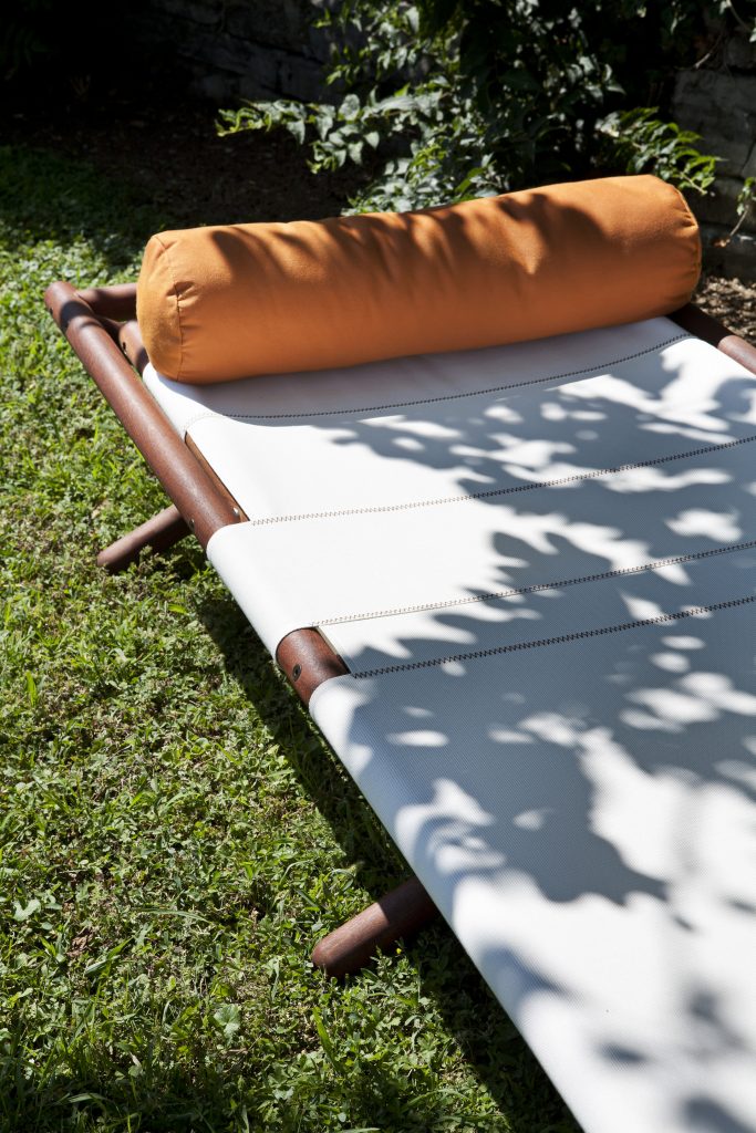 close up of the paraggi sun lounger with an orange pillow