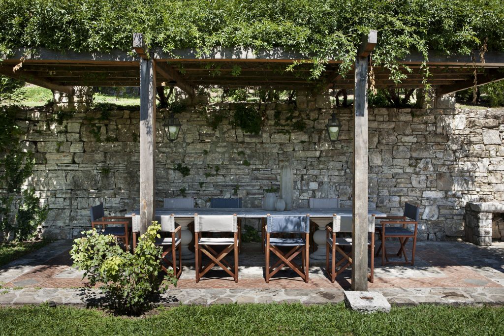 paraggi chairs on an outdoor dining area with a stone wall background