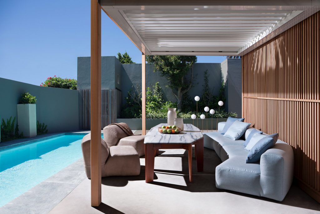 light brown soft arm chair as part of a outdoor living area next to a pool