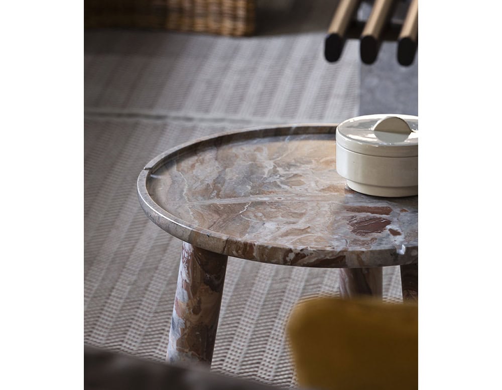 Stone Round Coffee Table in brown and gray stone on a gray floor.