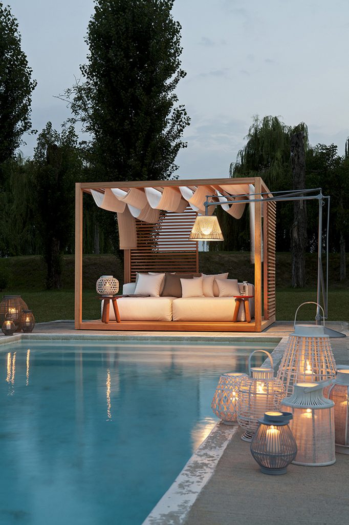 zen light cabana with a white outdoor sofa next to a pool