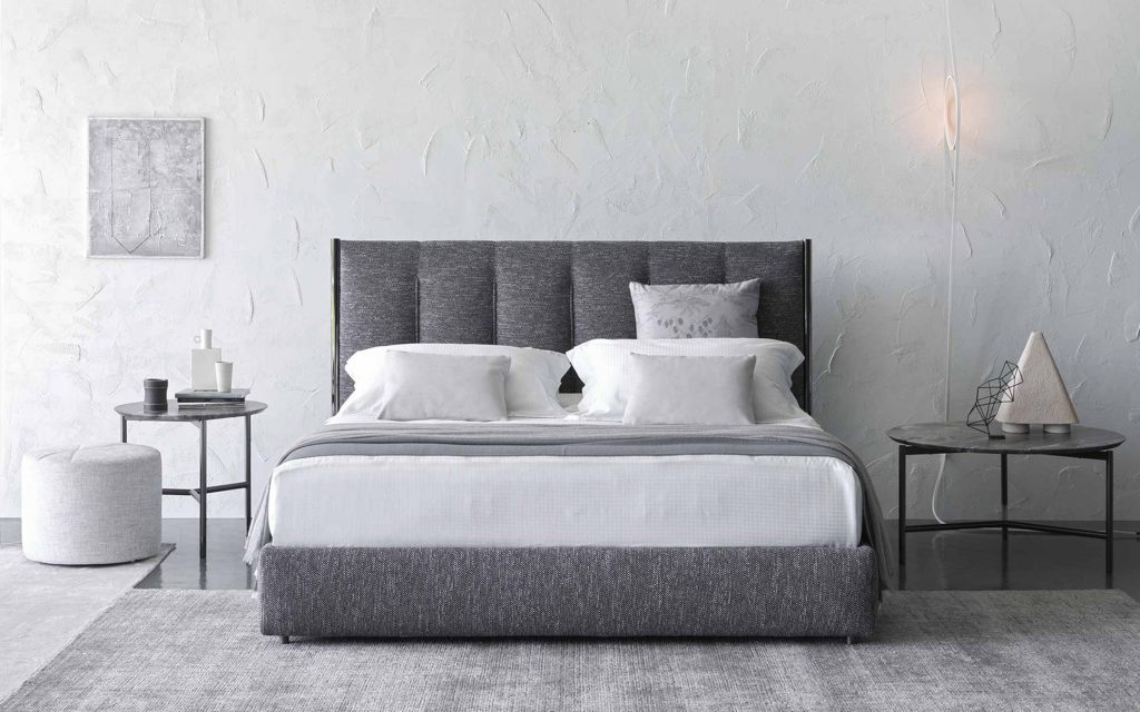 Koi double size bed upholstered in gray fabric, heardboard with vertical lines pattern in a bedroom.