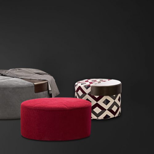 Three Moon poufs, one in gray, one in red and one in white and brown triangle pattern on a black background.