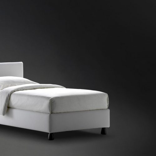 Notturno Single bed. Base and backrest covered in gray fabric and legs on a black background.
