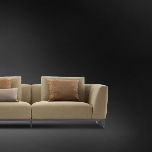 Olivier B sofa upholstered in brown fabric and four legs in steel on a black background.