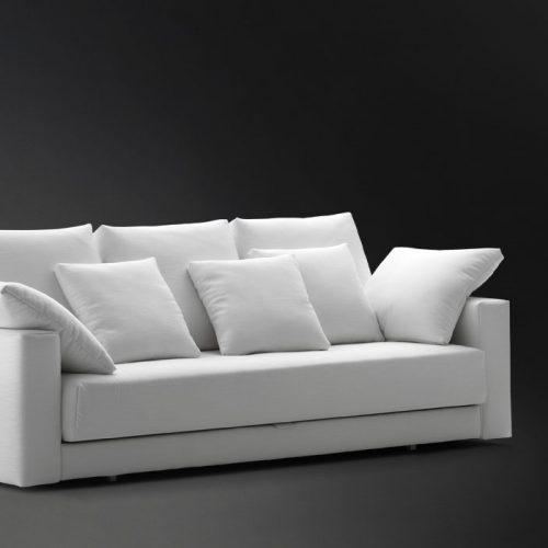 Three seater Piazza Duomo sofa and bed made of white fabric on a black background.