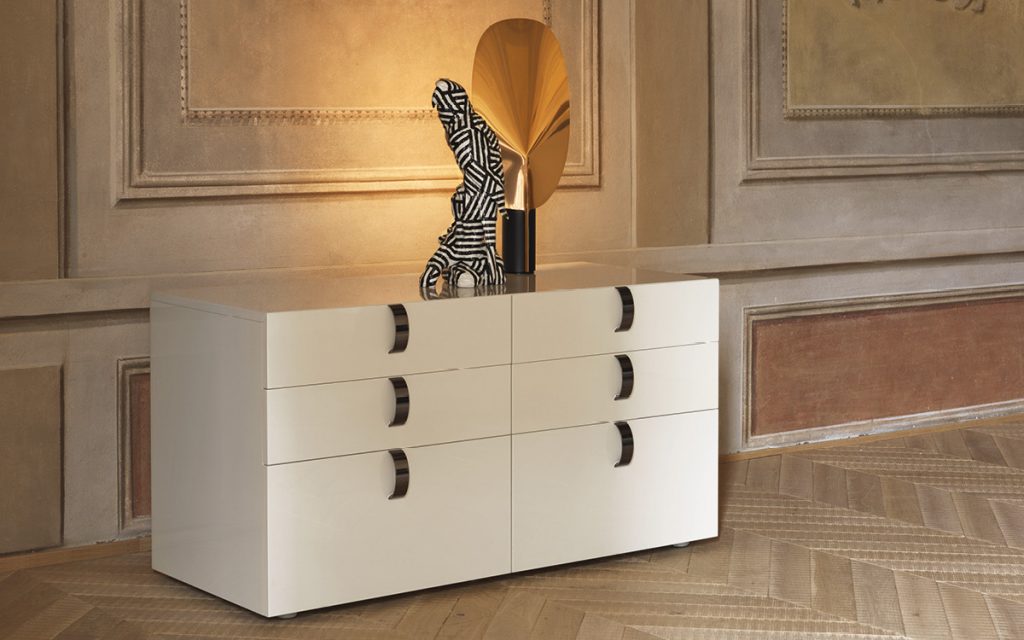 Splendor Dresser in white with handles in black nickel and two sculptures in a room.