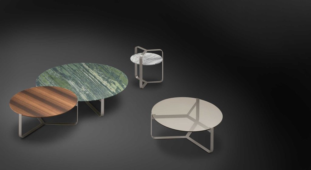 Four round Yari side tables. White, green and brown tops. Silver legs on a black background.
