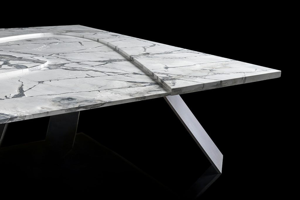 Closeup of Background Coffee Table. White and gray square top and four black legs on a black background.
