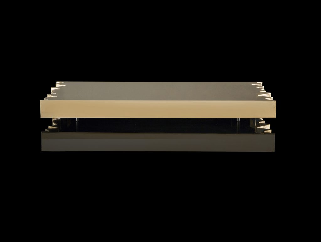 Rectangle Be Mine coffee table. Finish in brass with pointed edges on a black background.