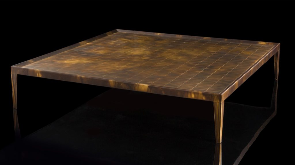 Square D Code Table top and four legs in brass on a black background.