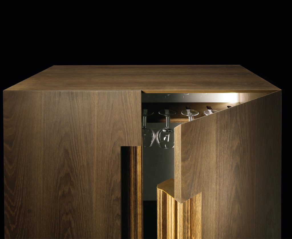 Rectangular frame Cabinet made of wood with closure and base in brass on a black background.