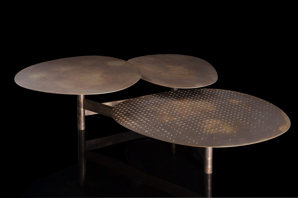 Galaxy table with three round giratory tables made of metal and brass on a black background.