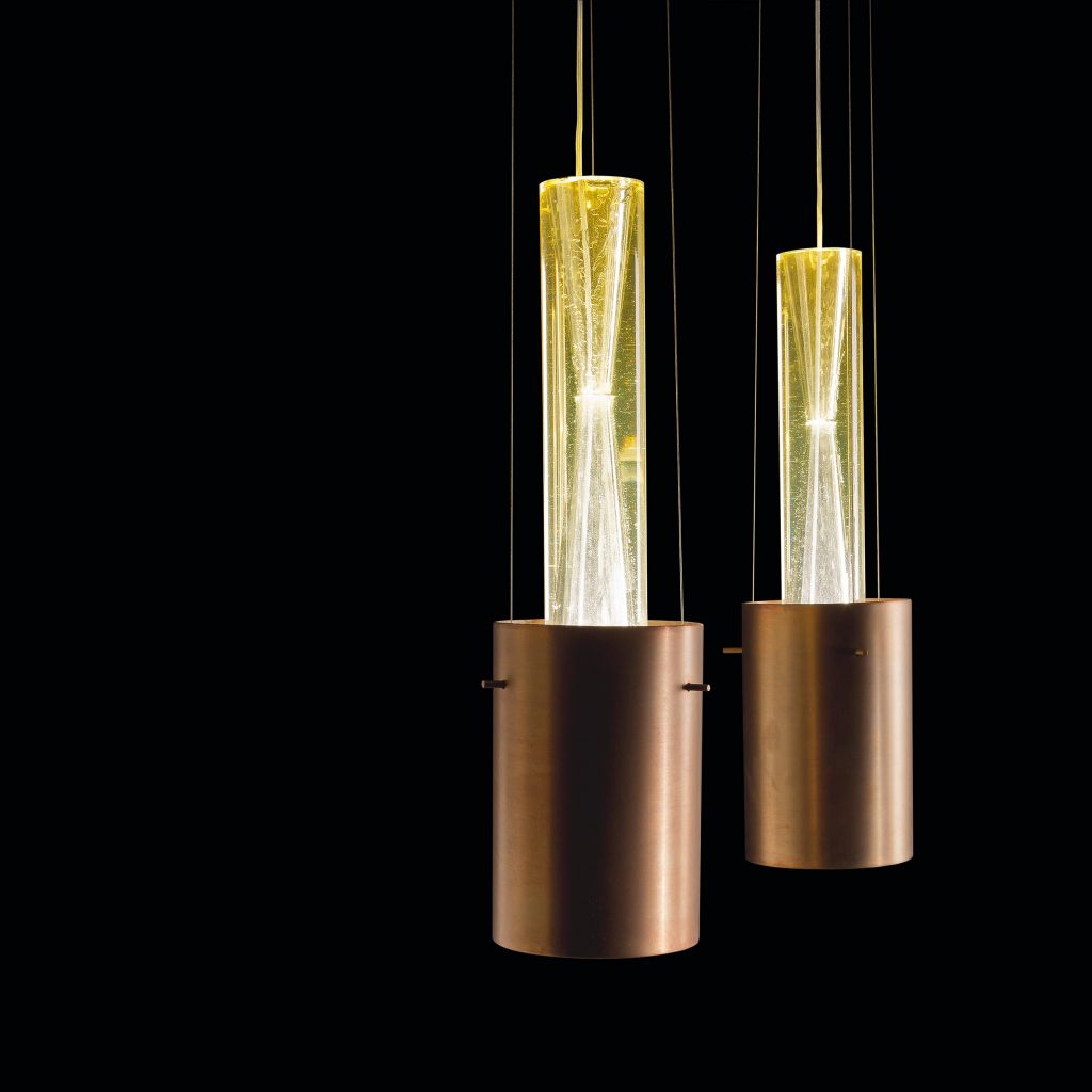 Two pendant Ghost Lights, Central element in resin, light diffuser in brass on a black background.