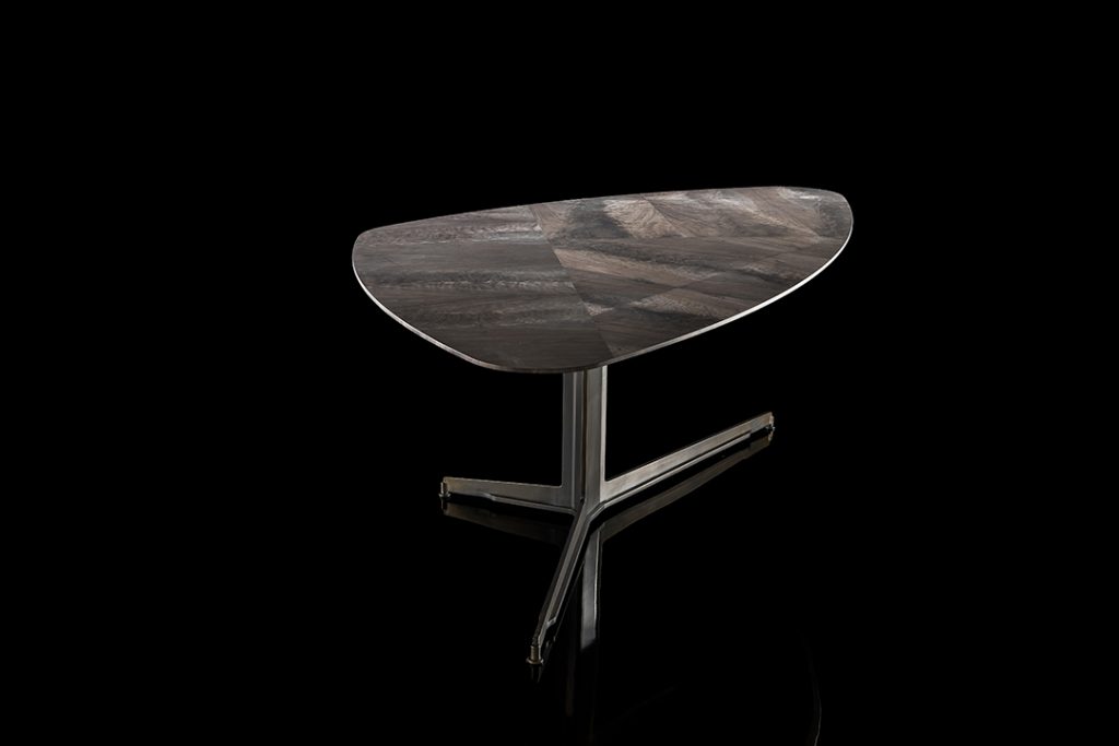 Gibson Coffee Table, top in wood and black steel central leg on a black background.