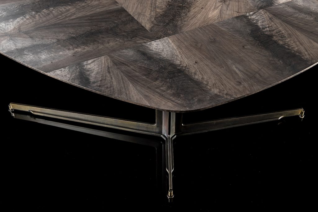 Gibson Coffee Table, top in wood and black steel central leg on a black background.