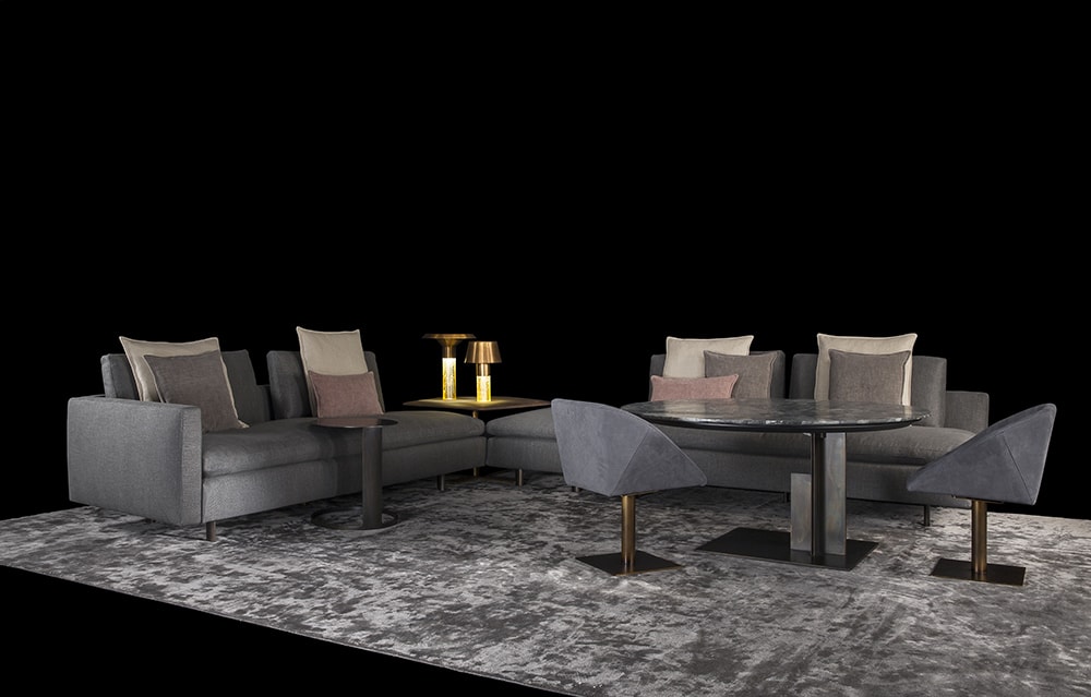 Two Human Sofas with armrest and backrest upholstered in gray fabric with black brass legs in a living room.