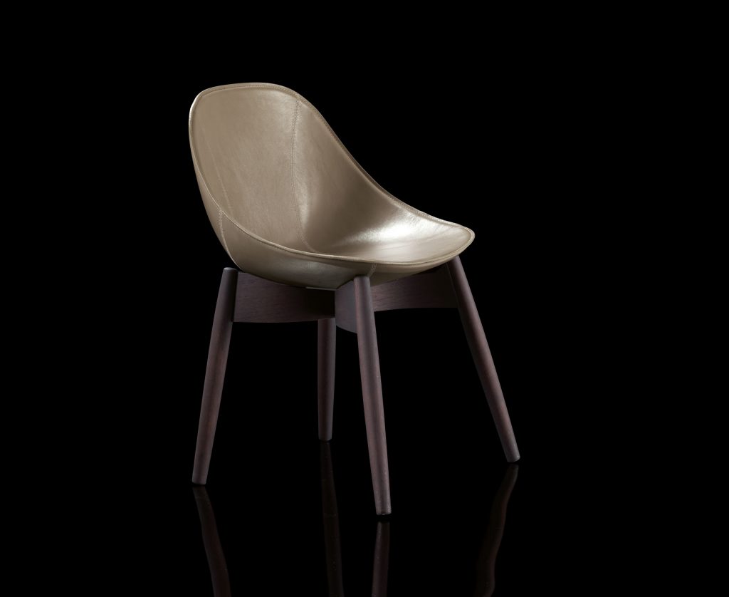 Dining June Chair, base and four legs in natural wood, cover in brown leather on a black background.