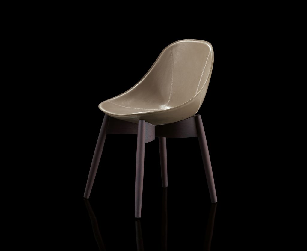 Dining June Chair, base and four legs in natural wood, cover in brown leather on a black background.