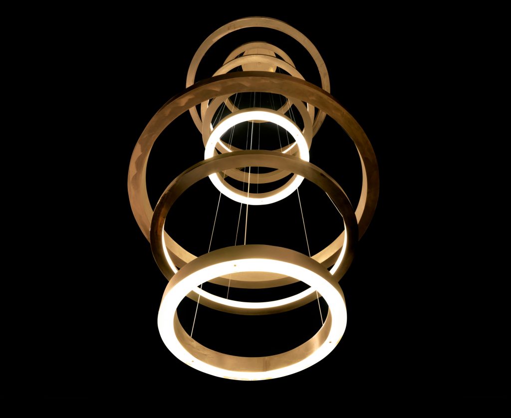 Light Ring XXL. Eight compositions made up of brass rings in different sizes and types of light emission using suspension wires on a black background.