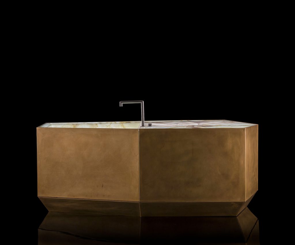 Ozone Evo kitchen bar, cover in brass, top and sink in white and brown irregluar pattern marble stone with black faucet on a black background.