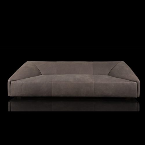 Three seater Radical Sofa, brown leather upholstery, shaped like an envelope and four legs in natural wood color on a black background.